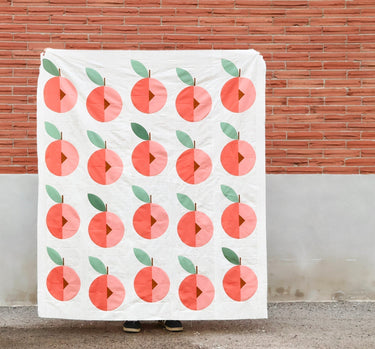 Finished Peach Street modern quilt top in Kona Solids against brick wall