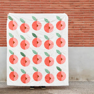 Finished Peach Street modern quilt top in Kona Solids against brick wall