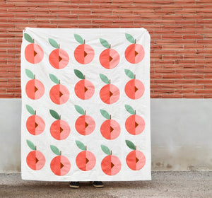 Finished Peach Street modern quilt top in Kona Solids against brick wall